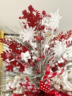 a red and white christmas tree decorated with snowflakes, candy canes and bows