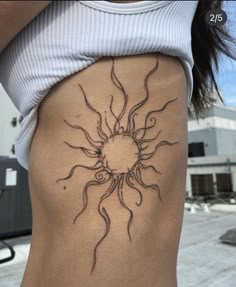 a woman's stomach with a sun tattoo on her lower back and the bottom part of her body