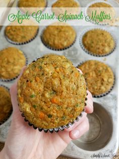 a person holding up a muffin in a muffin tin with the words apple carrot spinach muffins above it