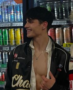 a man with no shirt standing in front of a display of sodas and drinks