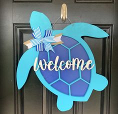 a welcome sign on the front door of a house with a sea turtle painted on it