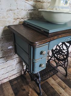 an old sewing table with a bowl on top