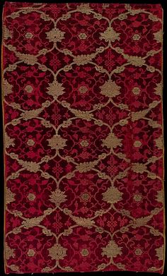 a red and gold rug with an intricate design on the bottom, in front of a black background