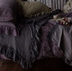 an old fashioned bed with ruffled bedspread and pillows