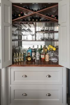 an open cabinet filled with bottles and glasses