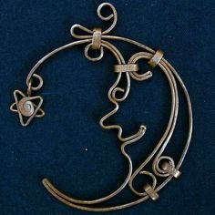 a metal object that looks like a crescent with an intricate design on the front and side