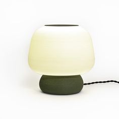 a lamp that is sitting on top of a table next to a black cord attached to it