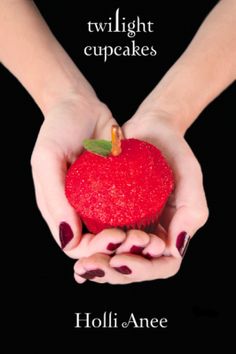 two hands holding a red apple with the words twilight cupcakes written on it