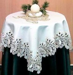 a table with a white and black cloth on it next to a christmas tree ornament