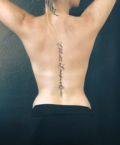 the back of a woman's body with writing on her lower back and upper back