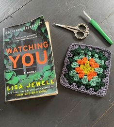 a crocheted book and pair of scissors are sitting on a table next to the book, watching you