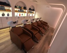 a row of brown chairs sitting in front of a wall filled with bottles and shelves