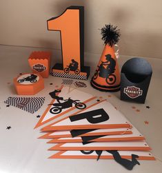 an orange and black motorcycle themed birthday party with paper hats, napkins, and decorations