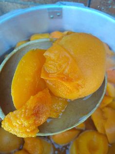 a spoon full of peeled oranges in water