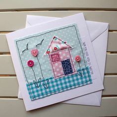 two cards with buttons on them sitting next to each other, one has a pink house