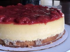 a cheesecake with raspberry sauce is on a white plate and ready to be eaten