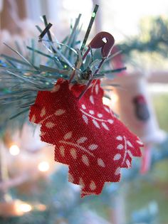 a red and white ornament hanging from a christmas tree