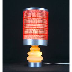 a lamp that is on top of a black surface with a red light in the middle