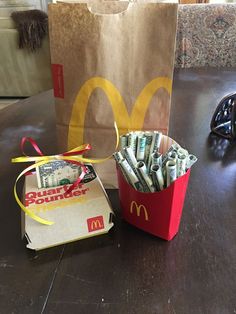 a paper bag with money in it next to a mcdonald's box on a table