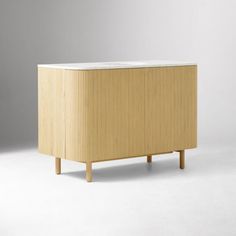 the sideboard is made out of wood and has a white marble top on it