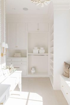 a room with white walls and shelves filled with items on top of each shelf in front of a chandelier