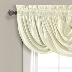 a white curtain hanging on the side of a window