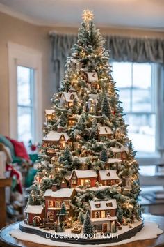 a christmas tree with lights and houses on it