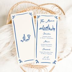 two blue and white menus sitting on top of a wicker basket