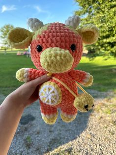 a small crocheted giraffe is being held by someone's hand