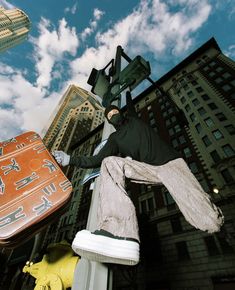 a man in black jacket standing on top of a metal pole