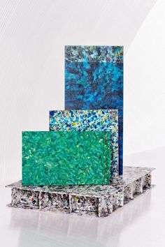 three pieces of art are stacked on top of each other and one piece is blue