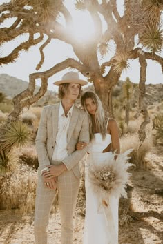 a man and woman standing next to each other in the desert