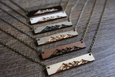 three necklaces that have mountains on them