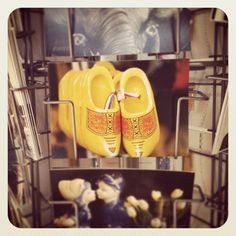 yellow shoes are on display in front of pictures and other items at a store or office