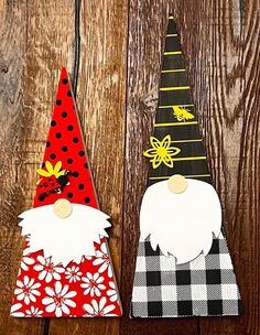 two gnomes made out of paper sitting on top of a wooden table