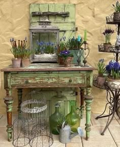 an old green table with flowers and plants on it