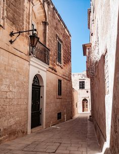 an alley way with stone buildings and doors