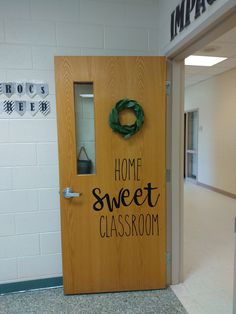 a wooden door with the words home sweet classroom written on it in front of an empty hallway