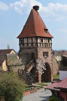 an old building with a red roof and stairs