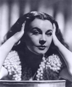 a black and white photo of a woman with her hands on her head