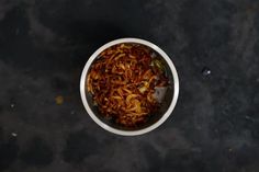 a white bowl filled with food on top of a table