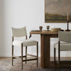 two chairs sitting at a table in front of a painting