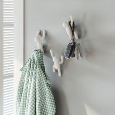 two towel hooks are attached to the wall next to a green and white checkered towel