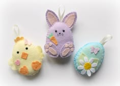 three felt easter decorations are shown on a white surface