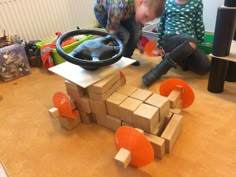 two children playing with wooden blocks in a room