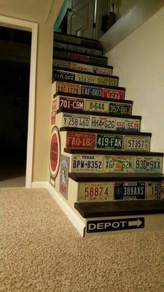 there is a staircase made out of license plates on the wall and carpeted floor