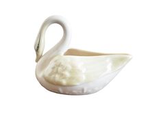 a white swan shaped bowl sitting on top of a table