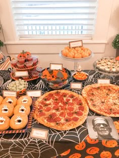 a table topped with pizzas and other foods