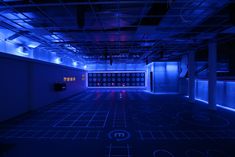 an empty room with blue lights and grids on the floor