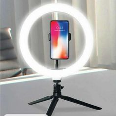 an iphone is sitting on a tripod in front of a window with the light turned on